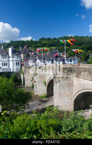 Llangollen Stone arched bridge over River Dee with various countries' flags flying from lamp posts Denbighshire North Wales UK Stock Photo