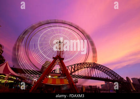 Luna Park ferris wheel blurred lights motion movement with Harbour Bridge in background Sydney New South Wales NSW Australia Stock Photo