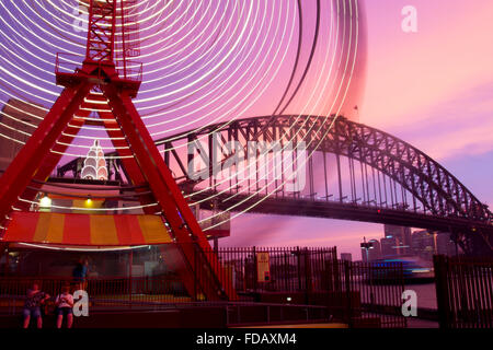 Luna Park ferris wheel blurred lights motion movement with Harbour Bridge in background Sydney New South Wales NSW Australia Stock Photo