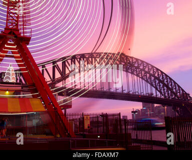 Luna Park ferris wheel blurred lights motion movement with Harbour Bridge in background Sydney New South Wales NSW Australia Stock Photo