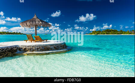 Two chairs and umbrella on a jetty on a tropical island, Maldives Stock Photo