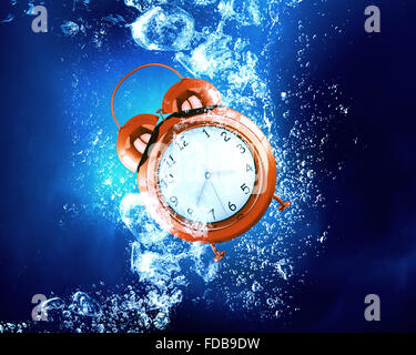 Alarm clock sink in clear blue water Stock Photo - Alamy