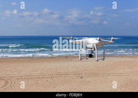 White remote controlled drone equipped with high resolution video camera hovering in mid air Stock Photo