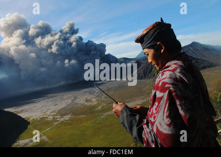 Probolinggo, EAST JAVA, INDONESIA. 30th Jan, 2016. Tenggerese performs a traditional dance called ''Ujung-Ujungan'' while the eruption of Mount Bromo in Probolinggo, East Java, on January 30, 2016. The ''Ujung-Ujung'' dance is one of the traditional dance and sports a distinctive combination of Tengger tribe, in the region of Mount Bromo in Probolinggo, East Java. This dance is played by two men who alternated hitting the opponent by using rattan. Credit:  Suryanto/ZUMA Wire/Alamy Live News Stock Photo