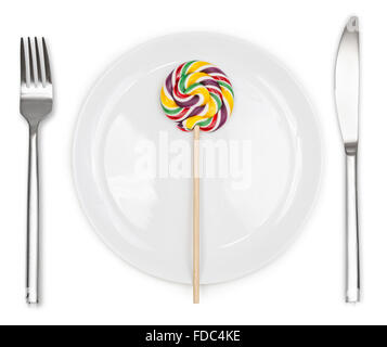 Colorful Lollipop in plate with knife and fork isolated on white background Stock Photo