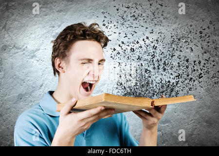 Young man with opened book and characters flying out Stock Photo