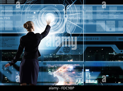 Rear view of businesswoman touching icon of digital screen Stock Photo