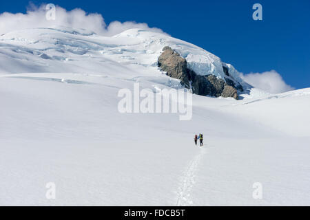 People walking among snows of New Zealand mountains Stock Photo