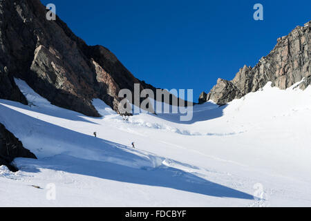 Group of people walking among snows of New Zealand mountains Stock Photo