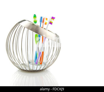 Tooth Brushes in contemporary wire basket holder on a white background Stock Photo