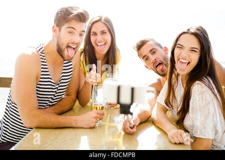 Group of friends at the beach bar and making a selfie Stock Photo