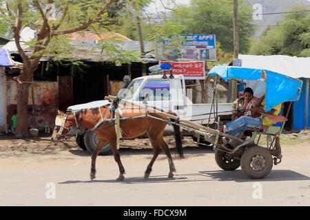 DEBRE BIRHAN, ETHIOPIA-MARCH 24: Horse carriage with canvas hood transports local people up the main street. Ethiopia. Stock Photo