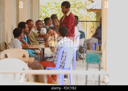 DEBRE BIRHAN, ETHIOPIA-MARCH 24: Local men gather on the porch of a bar beside the road-waiter serving them some local coffee. Stock Photo