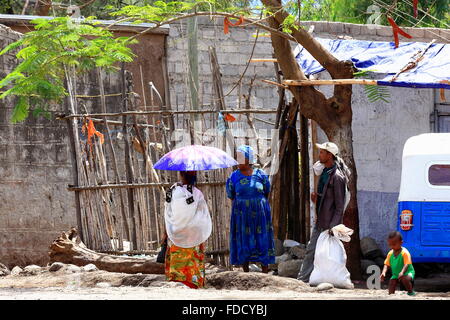 DEBRE BIRHAN, ETHIOPIA-MARCH 24: Local young woman with umbrella chats with neighbors on the street while waiting for the bus. Stock Photo