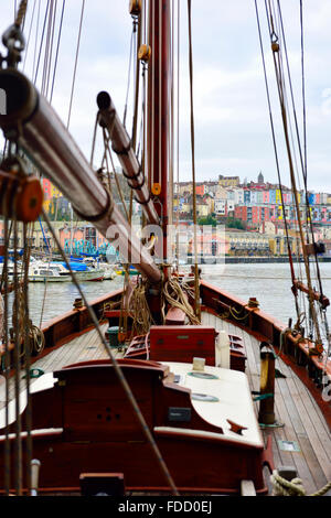 Looking through rigging of sailing yacht in Bristol floating harbour to colourful houses in Clifton Wood, England Stock Photo