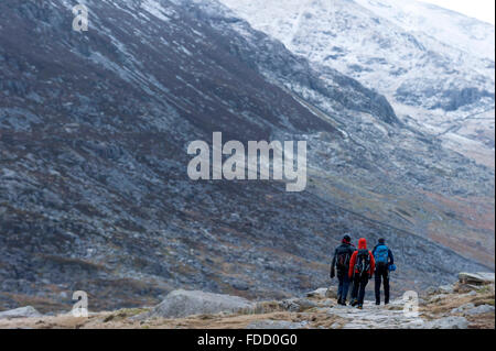 Snowdonia National Park, Gwynedd, Wales, UK. 30th January, 2016. Rock climbers descend near Llyn Ogwen at the end of the day. After an unseasonal mild spell, temperatures dropped to around zero this morning in Snowdonia National Park. A dusting of snow covers the peaks and there is a strong Westerly wind giving a much lower 'feels like' temperature. Credit:  Graham M. Lawrence/Alamy Live News. Stock Photo