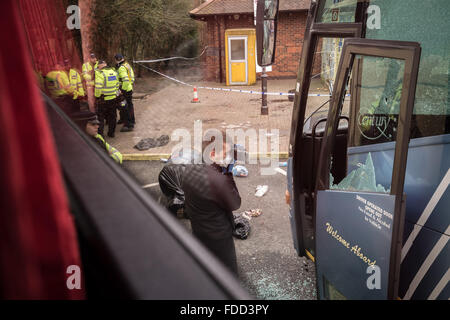 Kent, UK. 30th January, 2016. A police photographer documents evidence of damage to a coach by far-right protesters. A Far-Right nationalist groups violently clash with London anti-fascists at a Maidstone service station where coaches were also vandalised Credit:  Guy Corbishley/Alamy Live News Stock Photo