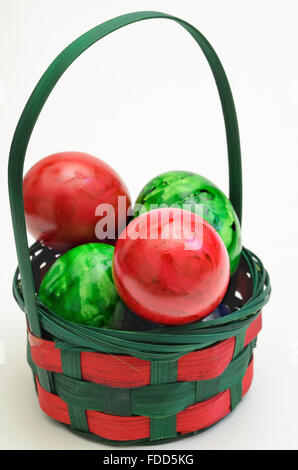 red and green  Easter eggs in a basket, close up, isolated on  white background,  vertical Stock Photo