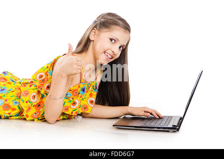 1 Child Girl Student Lying Down Laptop Working and Thumbs Up Showing Stock Photo