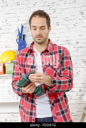 a young man with a drill, in his studio Stock Photo