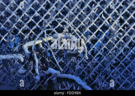 frost on chain link fence and bike Stock Photo