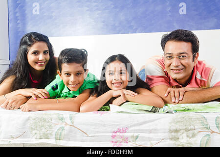 4 People Parents and Kid Bedroom Lying Down Relaxation Stock Photo