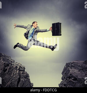 Image of young businessman jumping over gap Stock Photo