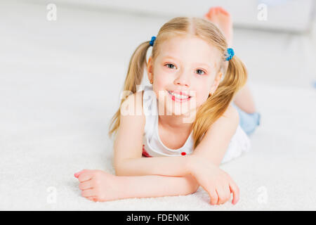 Cute happy girl lying on floor and dreaming Stock Photo