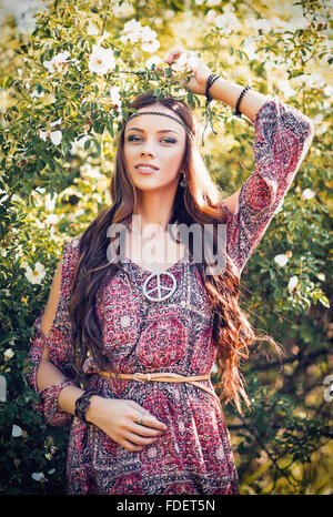 Portrait of a beautiful young hippie girl among the flowers Stock Photo