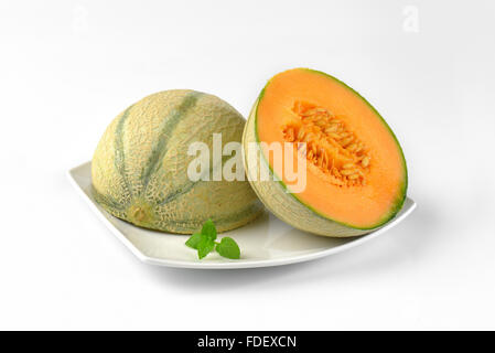 close up of halved cantaloupe melon on white plate Stock Photo