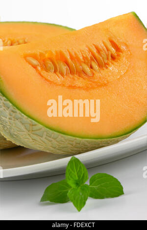 sliced cantaloupe melon on white plate Stock Photo