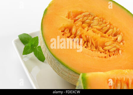 detail of halved cantaloupe melon on white plate Stock Photo