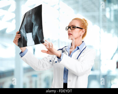 Portrait of female doctor examinig x-ray image. Isolated on white background. Stock Photo