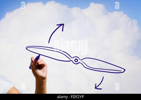 Person drawing plane propeller on sky background Stock Photo