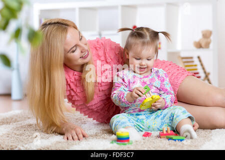 mother and her child playing with colorful puzzle toy Stock Photo