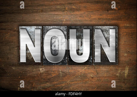 The word 'Noun' written in vintage metal letterpress type on an aged wooden background. Stock Photo