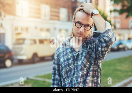 Portrait of Cool Blondie Man, wearing a blue shirt and glasses. City lifestyle Stock Photo
