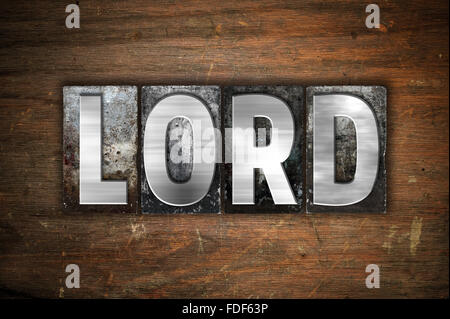 The word 'Lord' written in vintage metal letterpress type on an aged wooden background. Stock Photo