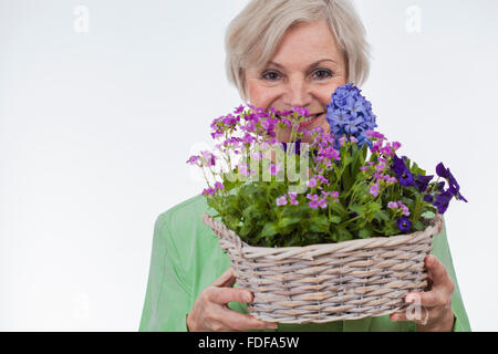 happy old senior woman on mothers day holding flowers smiling big smile Stock Photo