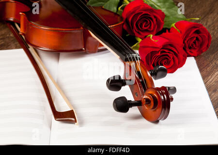 Red roses and a violin on the table Stock Photo