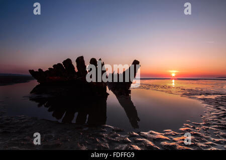 The wreck of the SS Nornen silhouetted at sunset on the beach at Brean Sands, Somerset, uk. Stock Photo