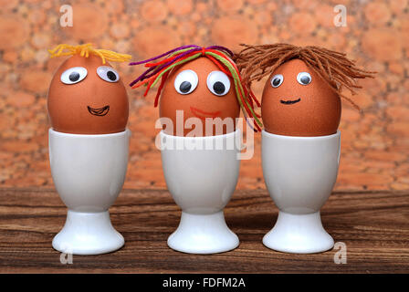 Eggs with faces in eggcups Stock Photo
