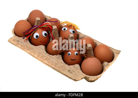 Eggs with faces in an egg box Stock Photo
