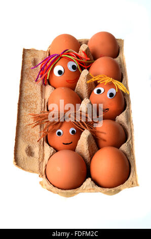 Eggs with faces in an egg box Stock Photo