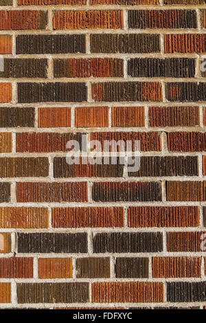 Multi coloured brick wall background and texture. Different bricks can be seen with groves and cement between them, Stock Photo