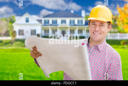 Smiling Contractor Holding Blueprints In Front of  Beautiful Custom Home. Stock Photo