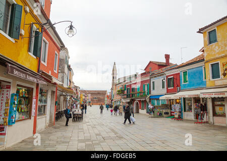 BURANO, ITALY - NOVEMBER 23: Brightly painted houses with people on November 23, 2015 in Burano, Venice, Italy. Stock Photo