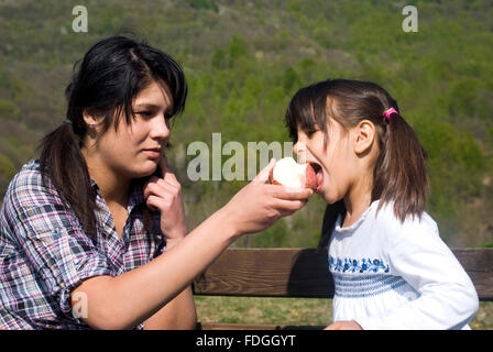 Two girls eating an apple Stock Photo