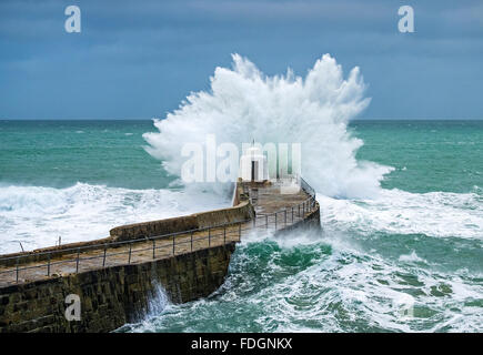 huge waves crash against the old pier at portreath in cornwall, uk, during a winter storm Stock Photo