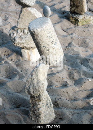 Rocks precariously balanced on top of one another as part of a rock stacking display on a Toronto beach. Stock Photo